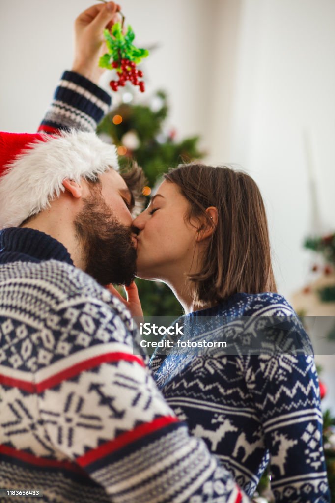 ヒイラギの葉の花輪を持ってキスするカップル, ヤドリギのカップルの写真, ヤドリギ,